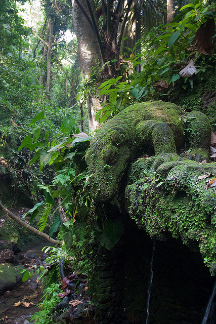 An overgrown statue of a Komodo dragon in the Sacred Monkey Forest, Ubud, Bali, Indonesia